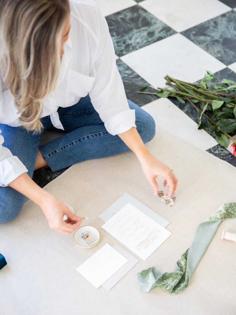 Wedding stationer styling a flat lay of an invitation